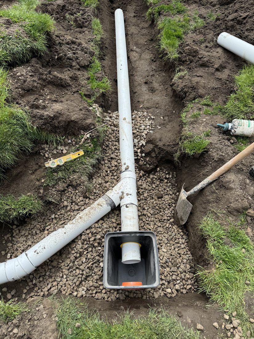 Drainage pipe connected to a catch basin in a trench